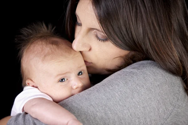 Real. Caucasian mother holding and kissing her one month old newborn baby boy — Stock Photo, Image