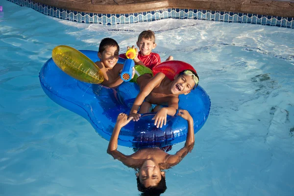 Летнее плавание. Группа маленьких мальчиков, играющих вместе на летнем солнце с водяными игрушками — стоковое фото