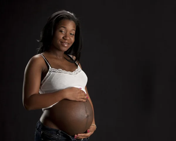 Real. Black expectant mother tenderly holding her abdomen — Stock Photo, Image