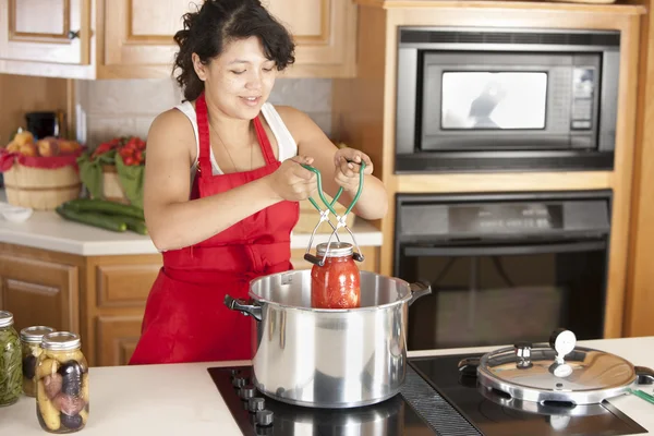 Canning. Mixed race young adult woman canning homegrown fruits and vegetables — Stock Photo, Image