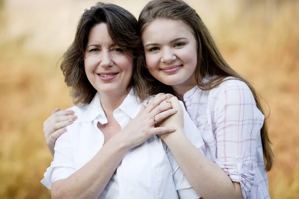 De verdad. Caucásica adolescente hija con sus brazos cariñosamente alrededor de su madre — Foto de Stock