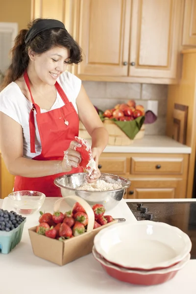 Horneando. Mezcla de raza joven mujer adulta hornear pasteles de frutas de postre en la cocina — Foto de Stock