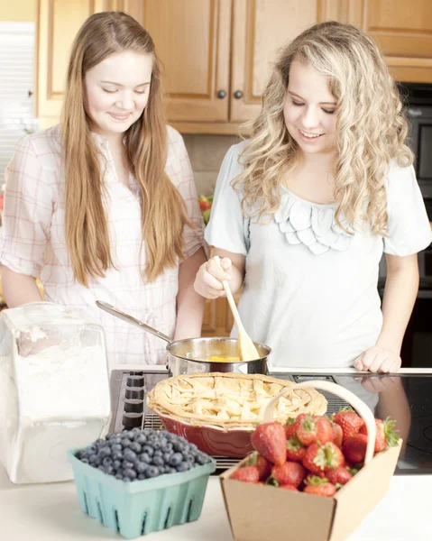 Sütés: Kaukázusi kaukázusi tizenéves barátnők így egy gyümölcs pie homegrown gyümölcs a konyhában — Stock Fotó