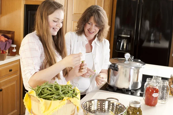 Canning. Kaukázusi anya és tizenéves lánya konzervipar homegrown zöldségek — Stock Fotó