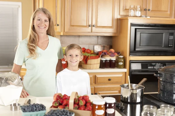 Canning. Mother and son canning homegrown fruits for preserves — Stock Photo, Image