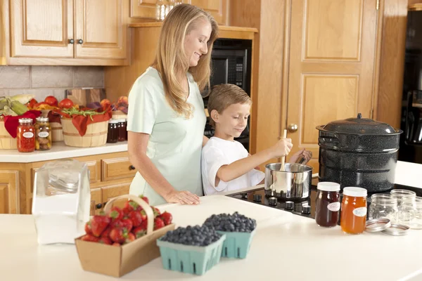 Canning. Mother and son canning homegrown fruits for preserves — Stock Photo, Image