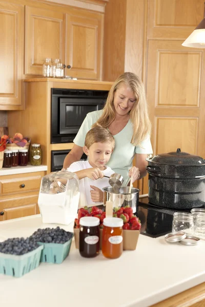 Canning. Mother and son canning homegrown fruits for preserves — Stock Photo, Image