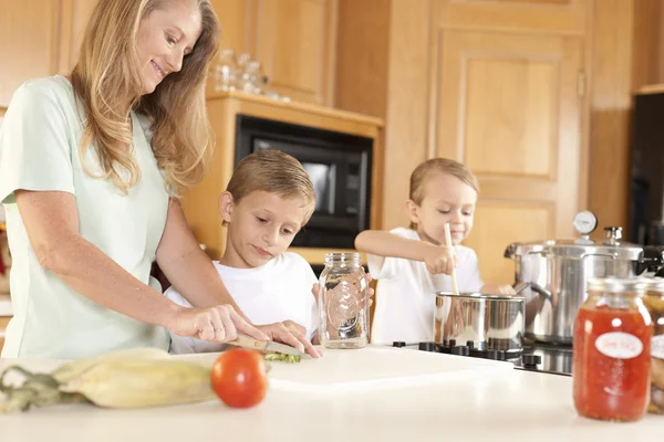 Inscatolamento. Madre e i suoi due figli conserviamo frutta e verdura fatta in casa — Foto Stock