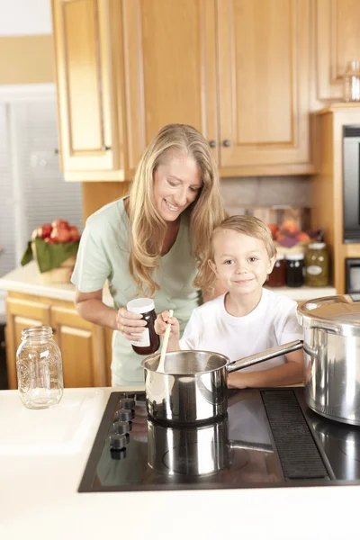 Canning. Mãe e filho enlatando frutas e legumes caseiros — Fotografia de Stock