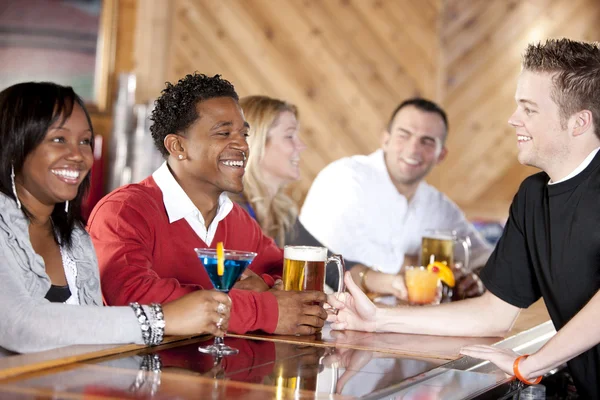 Young couples relaxing and enjoying themselves at a bar Stock Picture