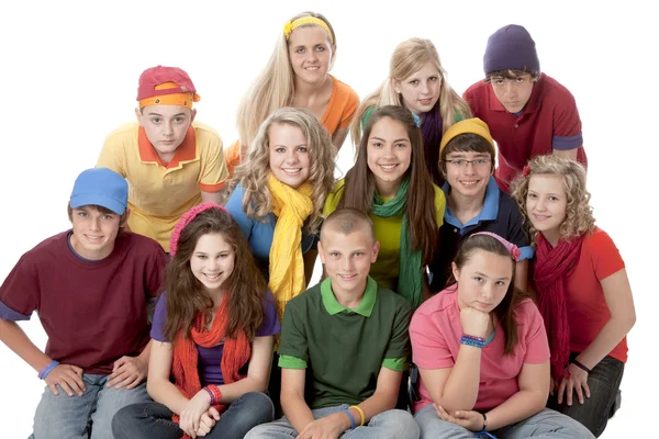 多样性。集团的十几岁的女孩和男孩一起坐在色彩鲜艳的衣服 图库图片