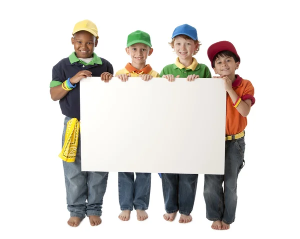 多样性。集团的四个不同的小男孩，举行一个空白的白色标志自定义 免版税图库图片