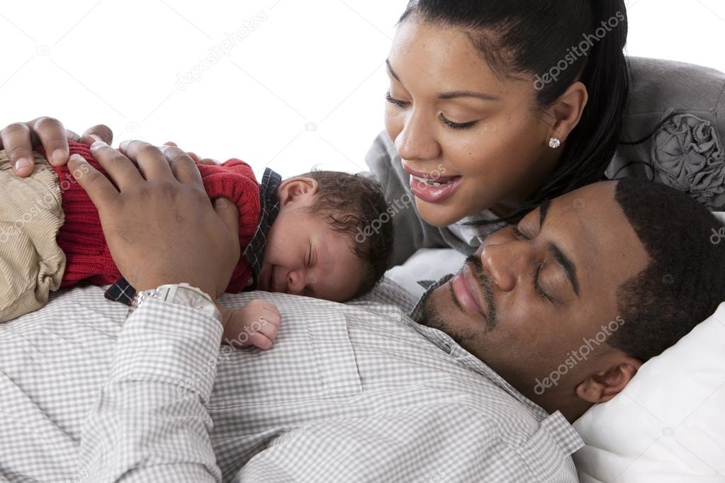 African american father holding his baby son on his chest