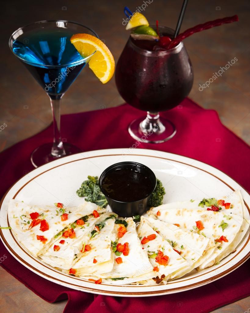 Food and Drink. An appetizer of cheesy quesadilla and cocktails