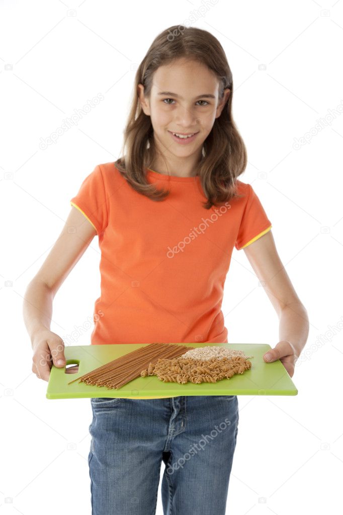 Healthy Eating. Caucasian little girl holding a tray of grains with an arrangement of pasta and rice