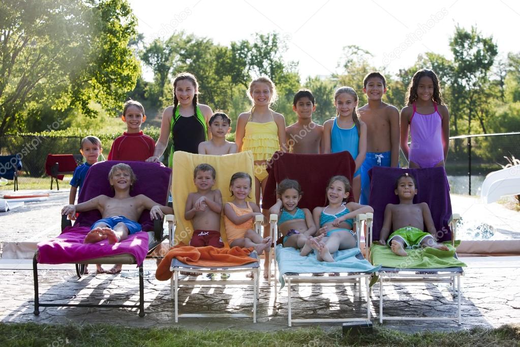 Summer Swimming. Group of diverse children relaxing after having fun in the summer sunshine