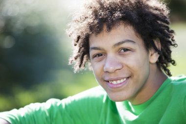 Güneş ışığında oturan karışık ırk genci