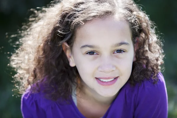 Real: Sonriente niña de raza mixta sentada bajo el sol —  Fotos de Stock