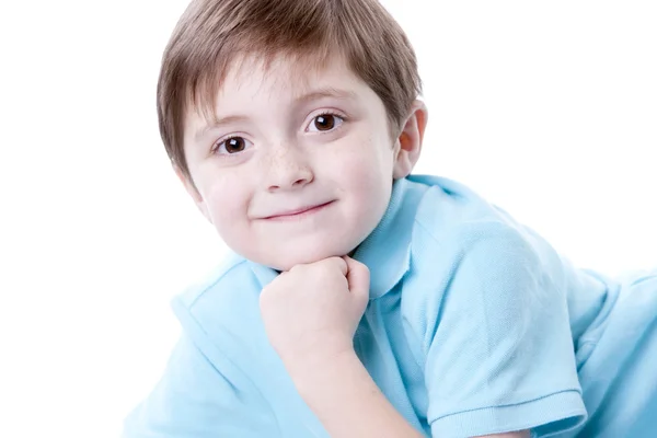 Sorrindo caucasiano menino descansando o queixo na mão . — Fotografia de Stock