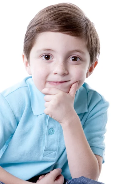 Sorrindo conteúdo caucasiano menino real pouco com a mão no queixo como se ele está pensando . — Fotografia de Stock