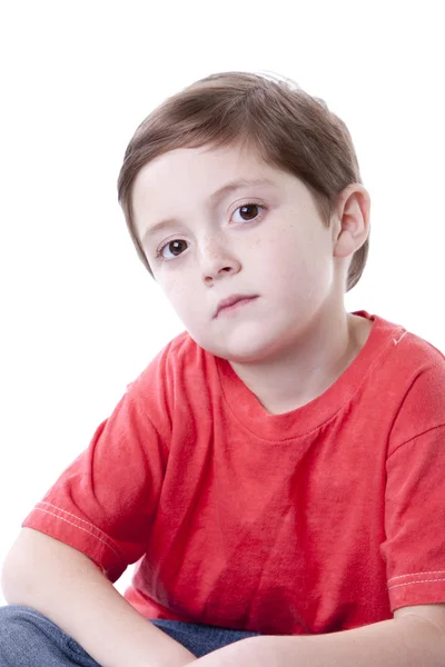 Niño caucásico serio sentado con las piernas cruzadas . — Foto de Stock