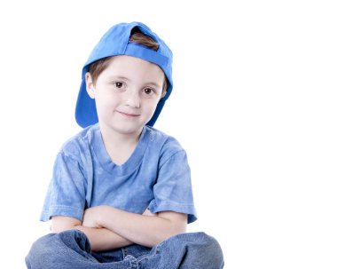 Smiling caucasian little boy sitting cross legged with his arms crossed clipart