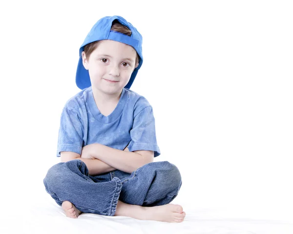 Sorrindo caucasiano menino sentado cruz perna com os braços cruzados — Fotografia de Stock