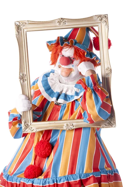 Клоуни. Дорослий чоловічий клоун тримає фоторамку навколо обличчя — стокове фото