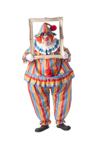 Klauni. Dospělý samec klaun držící rámeček obrázku kolem obličeje — Stock fotografie