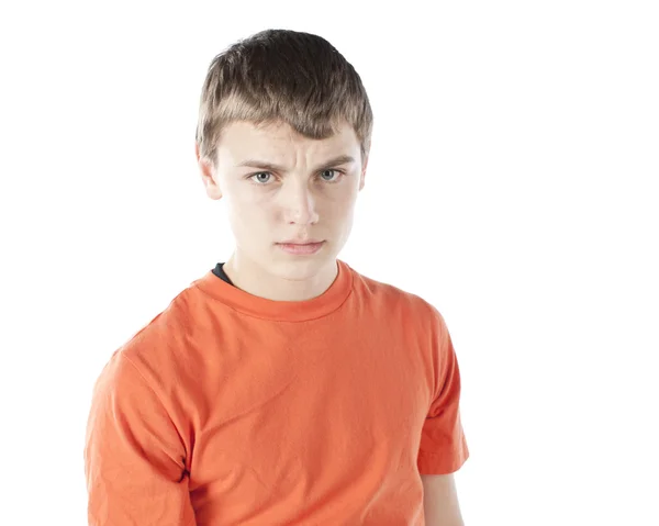 A frowning, concerned teenage boy wearing an orange t-shirt. — Stock Photo, Image