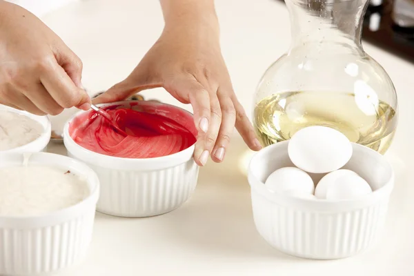 Un gâteau arc-en-ciel. chef mélange la pâte colorée pour préparer les couches pour le dessert — Photo