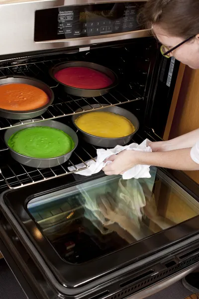 Bolo Arco-íris. Chef colocando panelas no forno para cozinhar — Fotografia de Stock