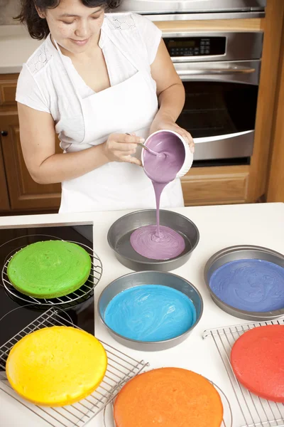 Regenbogenkuchen. Chef gießt Teig in Pfannen, um die bunten Schichten eines Regenbogenkuchens zu machen — Stockfoto