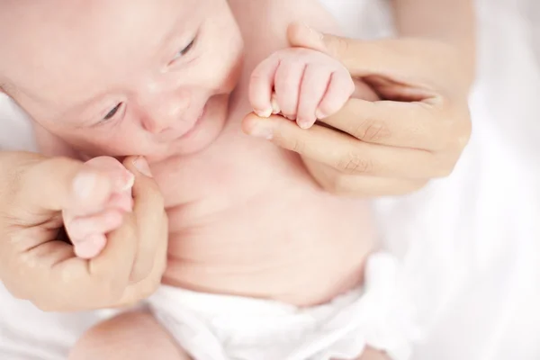 Handen met vreedzame Kaukasische pasgeboren babymeisje — Stockfoto