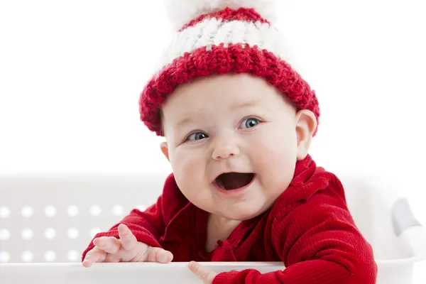 A chubby little baby girl, with blue eyes, dressed in red. — Stock Photo, Image