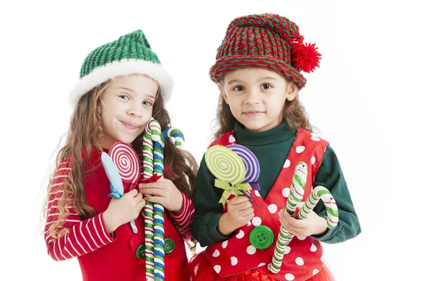 Dos pequeños elfos navideños sostienen bastones de caramelo y retoños —  Fotos de Stock