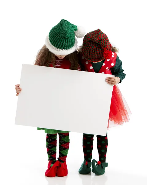 Weihnachtselfen halten leeres Schild für Weihnachtsbotschaft in der Hand — Stockfoto