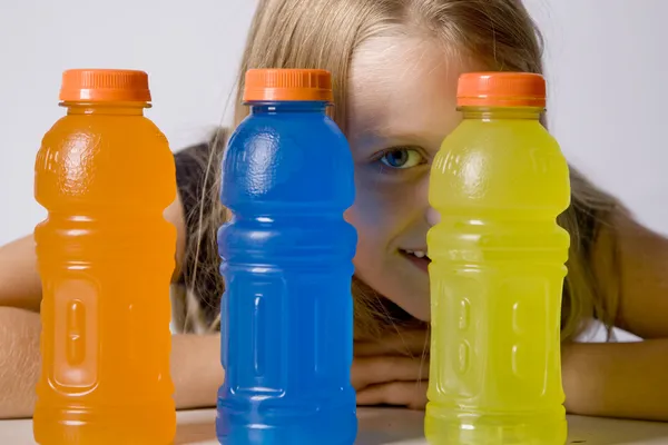 Junges Mädchen blickt zwischen Flaschen — Stockfoto