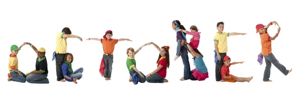 Multicultural children work together to form letters of the alphabet with their bodies — Stock Photo, Image