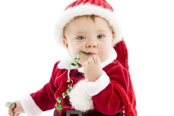 Funny baby girl eats christmas ribbon Stock Picture