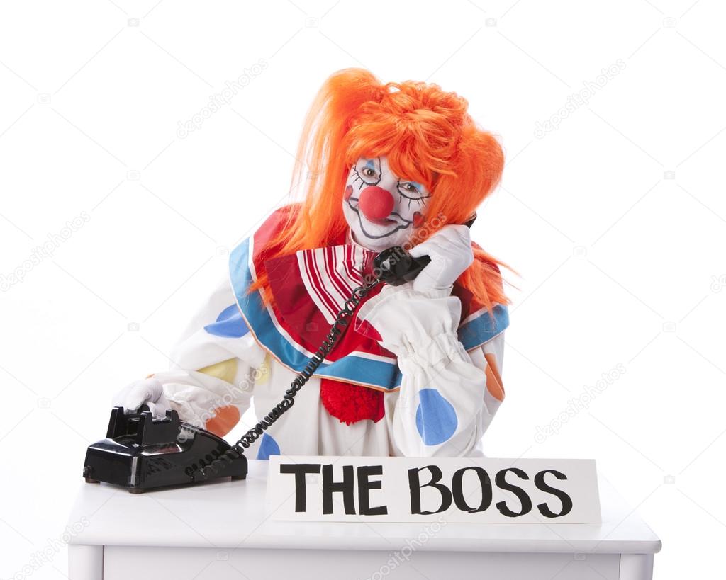 Clowns. Female clown boss talking on the phone for business