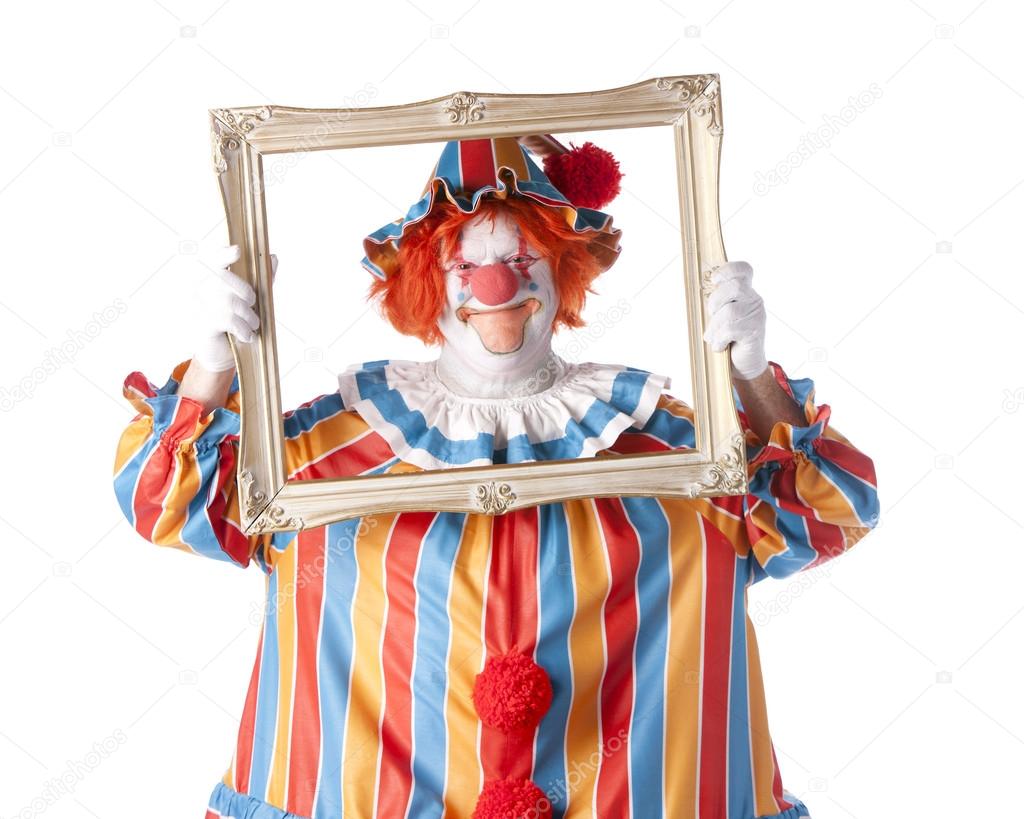 Clowns. Adult male clown holding a picture frame around his face