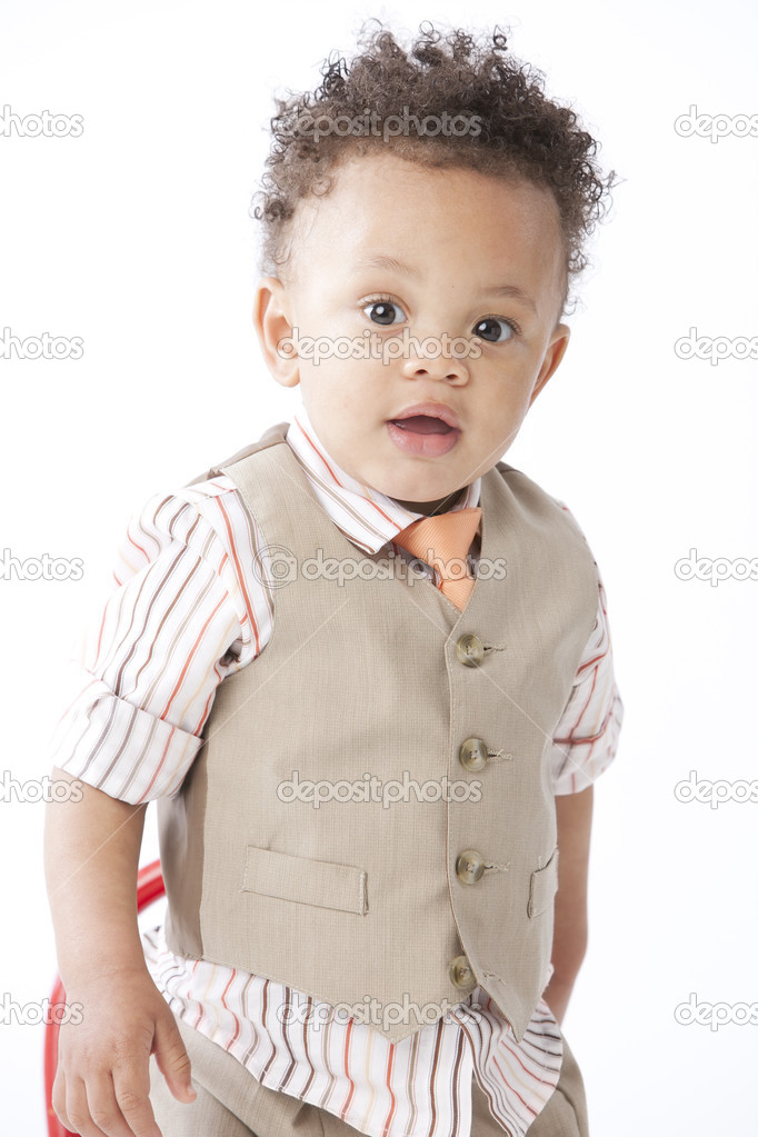 Black little boy dressed up in a button down shirt, vest and tie