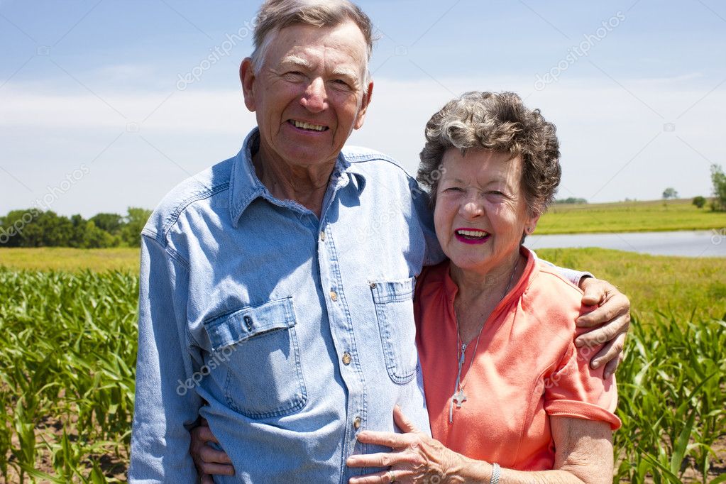 A proud hardworking midwestern grandmother and grandfather, farmers, stand proudly together in love