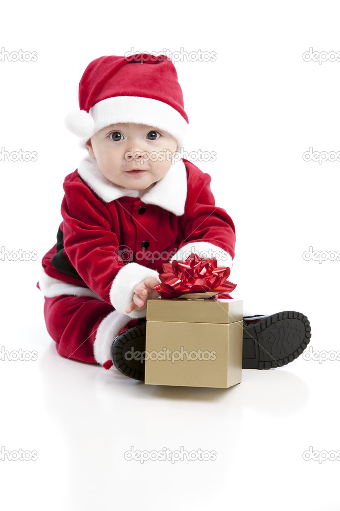 A happy little baby plays with a wrapped christmas gift