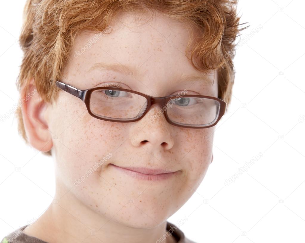A closeup headshot of a 9 year old caucasian smiling little real boy