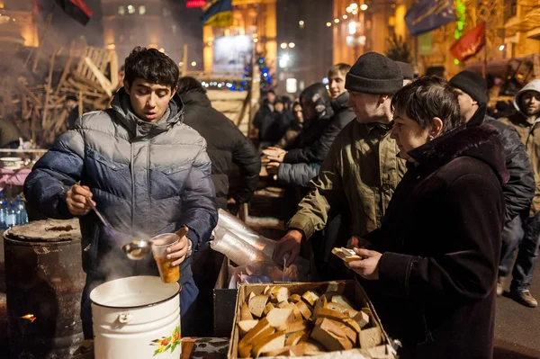 Maidan - Aktivist verteilt Suppe und Brot an Demonstranten Stockbild