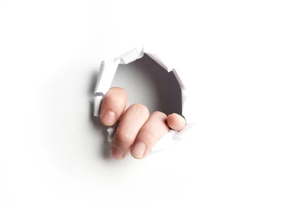 Hand showing trough a hole of a white paper — Stock Photo, Image