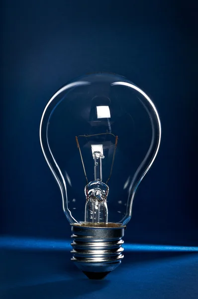 Light bulb on blue and black background — Stock Photo, Image