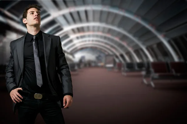 Successful business man at night with office buildings in the background — Stock Photo, Image
